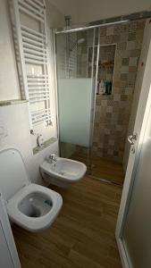 een badkamer met een toilet, een wastafel en een douche bij Il Vicolo agli Orti - Centro storico - Lake Como in Bellano
