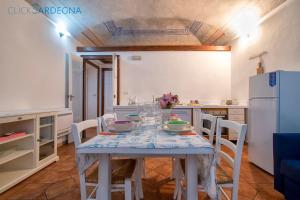 a kitchen with a table with chairs and a refrigerator at Carlo Alberto Apartment, Alghero old town, near the beach in Alghero