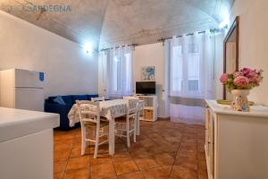 a kitchen and living room with a table and chairs at Carlo Alberto Apartment, Alghero old town, near the beach in Alghero