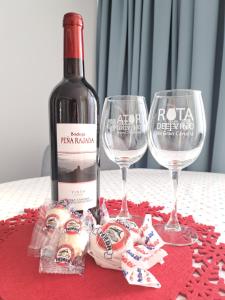una botella de vino y dos copas de vino en una mesa en Terraza Sol y Niebla en Tejeda