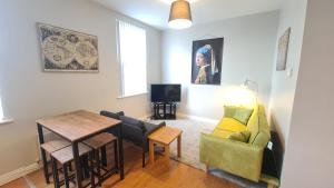 a living room with a couch and a table at Belfast Waterworks Apartments in Belfast