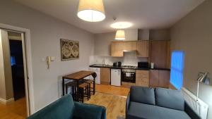 a living room with a couch and a kitchen at Belfast Waterworks Apartments in Belfast