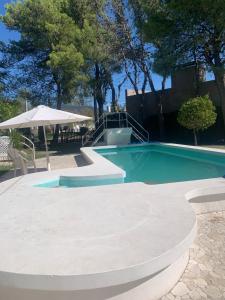 een klein zwembad met een tafel en een parasol bij Aire ju in Bahía Blanca