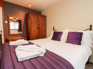 Un dormitorio con una cama grande con toallas. en Manorcombe 17, en Callington 24 fotos más