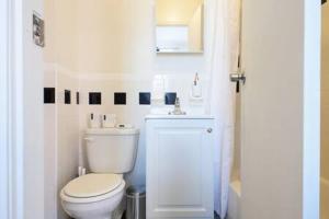 a white bathroom with a toilet and a sink at Renovated 1br in East Village in New York