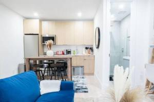 a living room with a blue couch and a kitchen at Brand new 2BR 1Bath East Village in New York