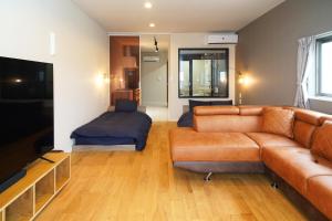 ein Wohnzimmer mit einem Sofa und einem Bett in der Unterkunft Etcetera Niijima Nagisa Building - Vacation STAY 02083v in Niijimamura