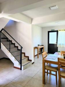 - un salon avec un escalier, une table et des chaises dans l'établissement Hospedaje El Toltén, à Junín de los Andes