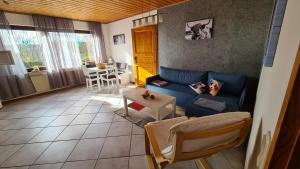 a living room with a blue couch and a table at Ferienwohnung Hanne in Netphen