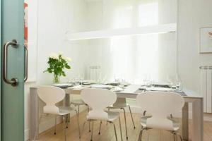 a white dining room with a table and white chairs at Classy 3bed 3bath apartment in Eixample in Barcelona