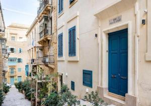 a building with a blue door on a street at Sea View Luxury Apartment Brand New in Valletta in Valletta