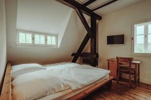 a bedroom with a bed and a table and a television at Museumsbahnhof Ahütte in Üxheim