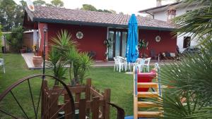 dom z ogródkiem z krzesłami i parasolem w obiekcie La Casa Di Isa w mieście Pontinia