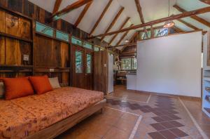 a bedroom with a bed in a room with wooden walls at Hotel Entre Dos Aguas in Sámara +179 photos