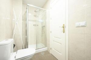 a white bathroom with a shower and a toilet at Capitan, 1 bedromm, city center & beach by 10TSea in Fuengirola