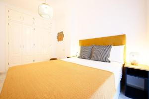 a bedroom with a large bed with a yellow blanket at Capitan, 1 bedromm, city center & beach by 10TSea in Fuengirola