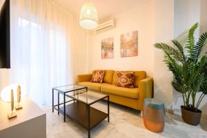 a living room with a yellow couch and a table at Capitan, 1 bedromm, city center & beach by 10TSea in Fuengirola