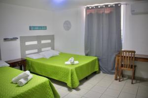 a bedroom with two beds with green sheets and towels at Villa Stahl in San Salvador