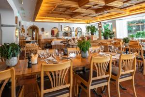 ein Restaurant mit Holztischen und -stühlen in der Unterkunft Studio im Hotel Des Alpes in Flims