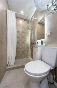 een badkamer met een wit toilet en een douche bij Шикарные апартаменты, Ревудского 40В, 3 мин пешком м Харьковская in Kiev