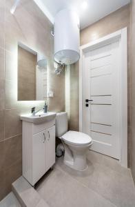 een badkamer met een toilet, een wastafel en een spiegel bij Шикарные апартаменты, Ревудского 40В, 3 мин пешком м Харьковская in Kiev