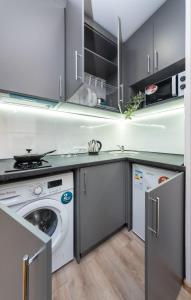 a kitchen with a washing machine and a washer at Шикарные апартаменты, Ревудского 40В, 3 мин пешком м Харьковская in Kyiv