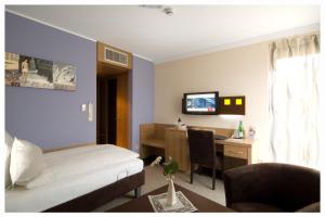 a bedroom with a bed and a desk with a computer at BurgStadt-Hotel in Kastellaun