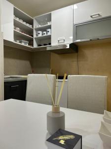 a kitchen with a white table with a vase on it at Apartman Marina Aranđelovac in Arandjelovac