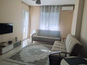 a living room with a couch and a tv at CITY CENTER 2 in Shkodër