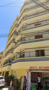 a large yellow building with people standing in front of it at Cosy studio Yellow House bamburi in Mombasa
