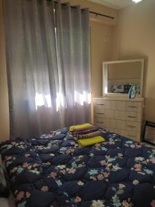 a bedroom with a bed with a blue comforter and a dresser at CITY CENTER 2 in Shkodër