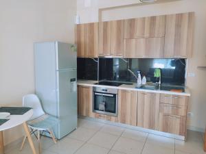 a kitchen with wooden cabinets and a refrigerator at CITY CENTER 2 in Shkodër +5 photos
