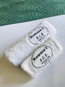 two towels with writing on them sitting on a bed at Nomusa's Bed and Breakfast in Richards Bay
