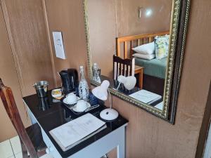 einen Spiegel an der Wand mit einem Schreibtisch in einem Zimmer in der Unterkunft Nomusa's Bed and Breakfast in Richards Bay