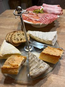 une assiette de pain et de sandwichs sur une table dans l'établissement Chambres d’hôtes de l’Ancienne Auberge, à Thaon