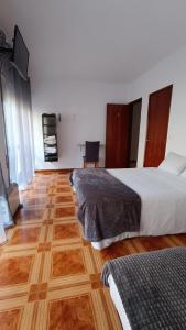 1 dormitorio con 2 camas y suelo de madera en Residencial S. Gião, en Valença