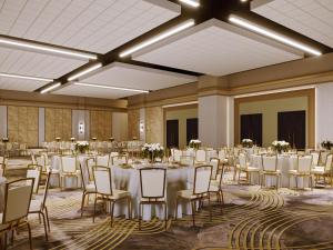 un salón de banquetes con mesas y sillas blancas en Terre Haute Casino Resort, en Terre Haute