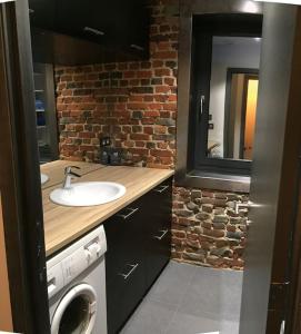 a bathroom with a sink and a washing machine at Duplex style industriel à deux pas de la Place in Bertrix