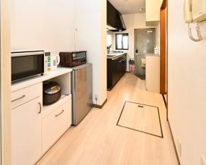 a room with a kitchen with a tv on a counter at Rose Park Nibankan - Vacation STAY 71056v in Funabashi