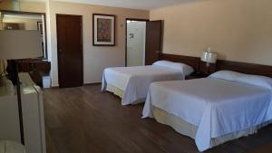 a hotel room with two beds with white sheets at Hotel Las Palmas Midway Inn in Matehuala +24 photos