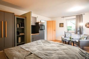 een slaapkamer met een bed en een woonkamer bij Apartment Ostersiek- privater Eingang mit eigener Terrasse in Bad Salzuflen