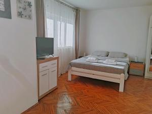a bedroom with a bed and a flat screen tv at Apartmani Bojana in Rovinj