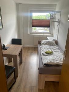 1 dormitorio con cama, escritorio y ventana en FeWo Wieko Plauen Leibnizstr. H1, 2.OG rechts, en Plauen