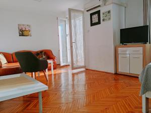 a living room with a wooden floor and a television at Apartmani Bojana in Rovinj