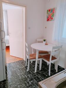 a white table and chairs in a room at Apartmani Bojana in Rovinj