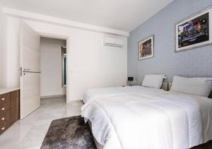 a white bedroom with a large white bed in it at Sea View Luxury Apartment Brand New in Valletta in Valletta