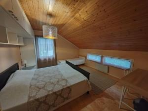 a bedroom with a bed and a wooden ceiling at Perinnetalo Taimela / Heritage House Taimela -homestay in Rovaniemi