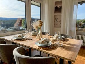 a dining room table with glasses and plates on it at Feldbergblick mit Schwimmbad und Sauna in Lenzkirch