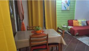 - une chambre avec une table, des chaises et un canapé dans l'établissement Escale chez Joëlle & Alain, au Lamentin