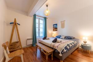 a bedroom with a bed and a wooden chair at "Hinkley" Centre ville Place de parking privé in Dieppe